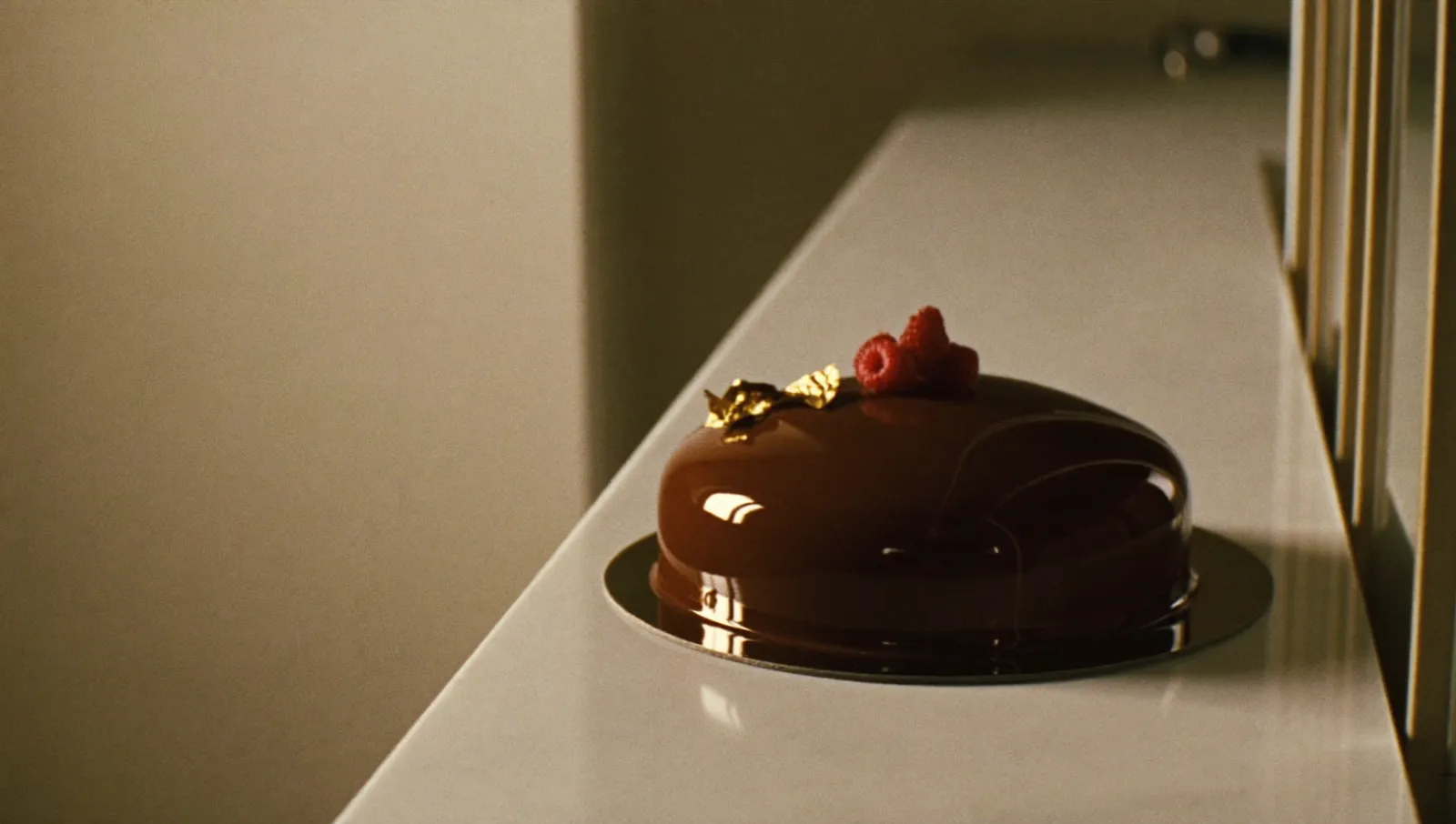 Entremets au glaçage miroir sur un marbre, lumière du matin